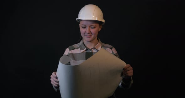 Young Female Engineer Is Studying a Construction Plan