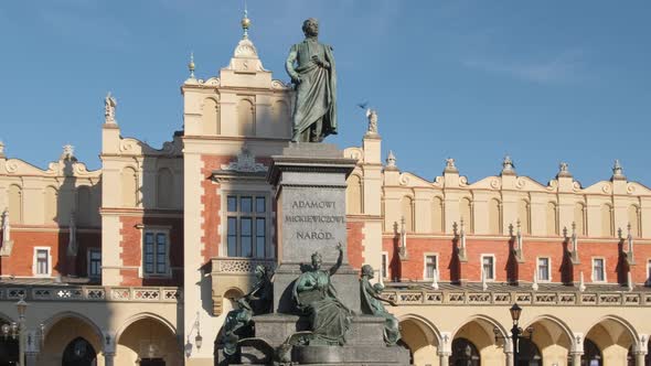 Statue of Adam Mickiewicz and Sukiennice Buidning in Cracow Poland