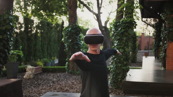 Bald Young Man in VR Headset and Black Sportswear