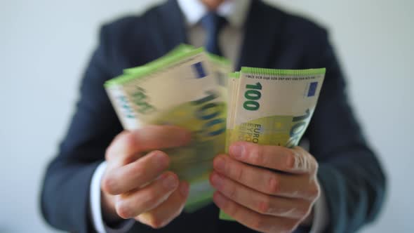 Formally Dressed Man Counting Euro Banknotes