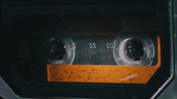 Vintage Yellow Audio Cassette Tape Rotates in Deck of an Old Tape Recorder