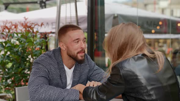 a Couple is Sitting at a Table in an Outdoor Cafe