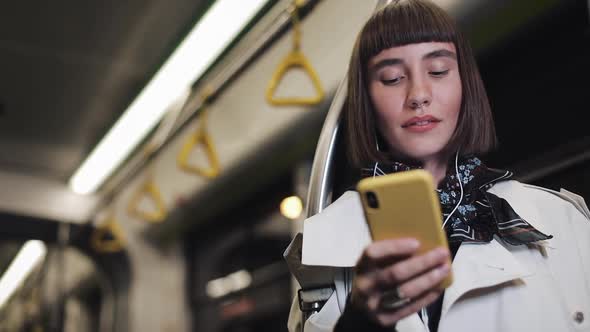 Portrait of Smiling Young Woman in Headphones Riding in Public Transport, Listen Music and Browsing