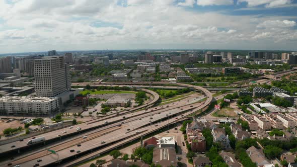 Forwards Fly and Tilt Down Footage of Large Busy Multilane Highway Interchange in Town