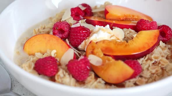 Summer oatmeal with raspberries, peaches and nuts.