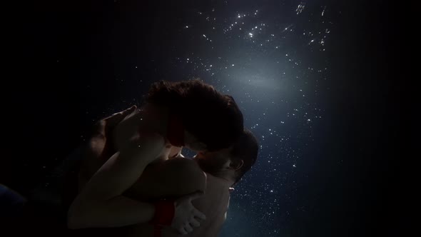 Romantic Couple Inside Dark Water of Ocean or Pool Embracing Man and Woman Love and Tenderness