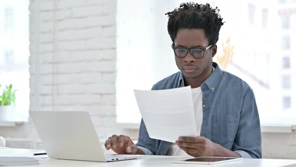 Young African Man Working on Document 