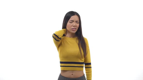 Slow Motion Attractive East Asian Woman Wearing Cropped Top Grimacing Discomfort Messaging Back Neck