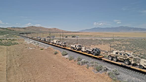 Train loaded with military vehicles moving through the Utah desert