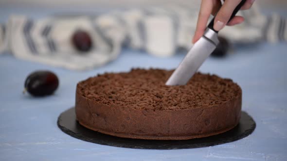 Cutting Homemade Shortbread Chocolate Cake with Plums