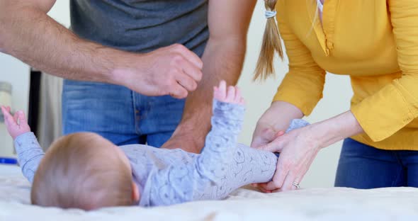 Parents wearing dress to their baby on bed 4k