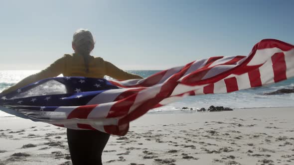 Woman holding American flag on the beach