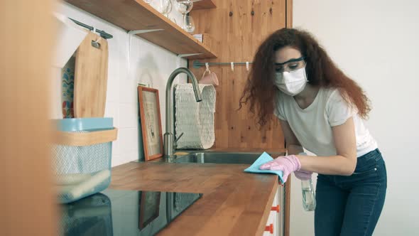 Coronavirus, COVID-19 Prevention Concept. A Lady Is Cleaning Table Surface with a Sanitizer