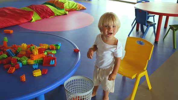 a Small Child Plays with a Construction Set and Claps His Hands