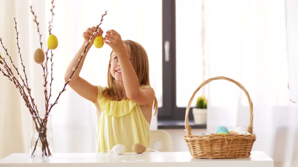 Girl Decorating Willow By Easter Eggs at Home