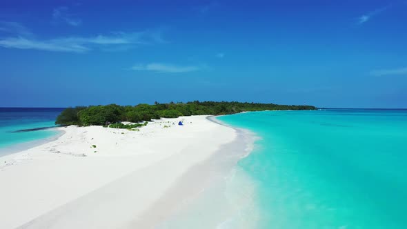 Daytime overhead island view of a sunshine white sandy paradise beach and blue ocean background 