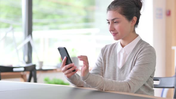 Excited Indian Woman Celebrating Success on Smartphone 