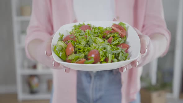 Unrecognizable Caucasian Woman Showing Fresh Tasty Salad at Camera