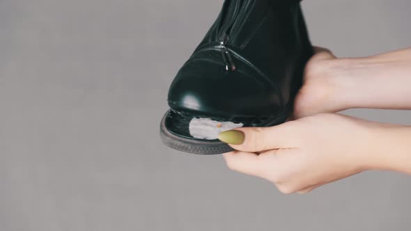 Female Hand Holds a Boot with a Torn Off Sole on a White Background Shoe Talks