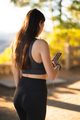Attractive young woman in fitness sportswear using smart phone for outdoor run workout - PhotoDune Item for Sale