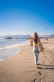 Attractive young woman walking towards Santa Monica beach pier - PhotoDune Item for Sale