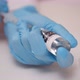 Close Up of Doctor Hands in Blue Protecting Gloves Fills the Vaccine From the Vial Into the Syringe - VideoHive Item for Sale