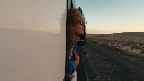 Adult traveler woman outside the window of her modern van camper . Concept of transport