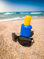 Closeup image of sunglasses and sunscreen lotion on the sandy sea beach. Perfect image for - PhotoDune Item for Sale