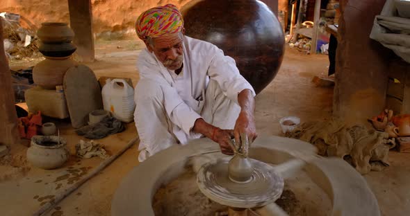 Skilled Professional Potter Throwing the Potter's Wheel and Shaping Traditional Ceramic Vessel and