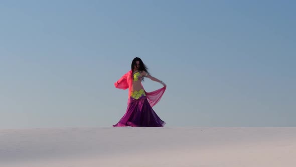 Professional Dancer in the Sandy Desert in the Hands of a Pink Pink Veil
