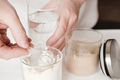 close up of woman making whey protein drink in a glass and jar with protein powder - PhotoDune Item for Sale