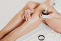 woman applying body butter on legs after shugaring procedure. depilation and after shave skin - PhotoDune Item for Sale