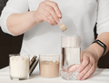 Woman making whey protein cocktail in the morning. hand holding a scoop og protein powder - PhotoDune Item for Sale