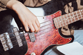 close up view of female hands playing elecrtic bass guitar. crop view. rock concert performance - PhotoDune Item for Sale