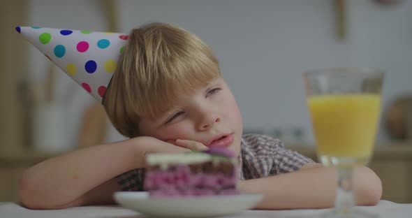 Portrait of Pensive Preschool Birthday Kid Looking at Piece of Cake and Sighing Sadly. Child Is