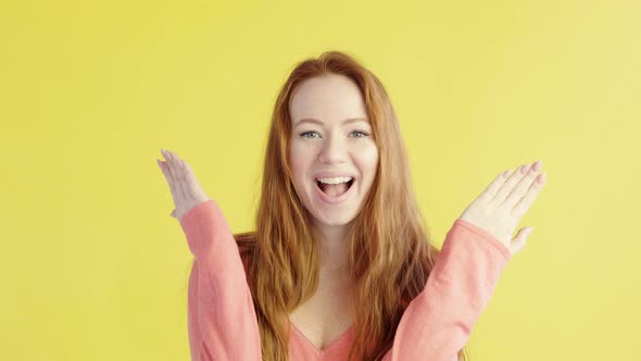 portrait  girl playfully looks into camera covers face with her hands and laughs