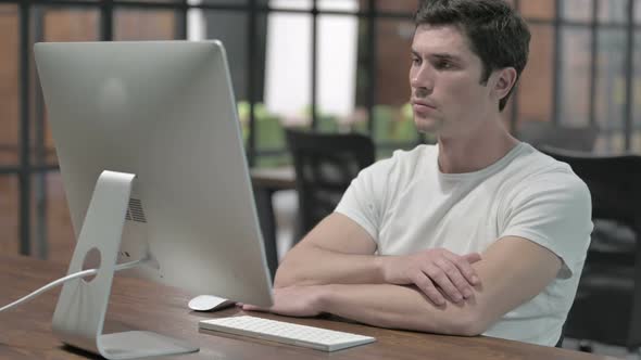 Man Thinking While Working on Computer