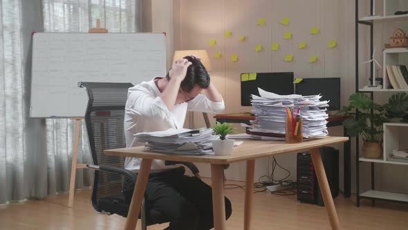 Tired Asian Man Shaking His Head And Taking Off His Glasses While Working Hard With Documents
