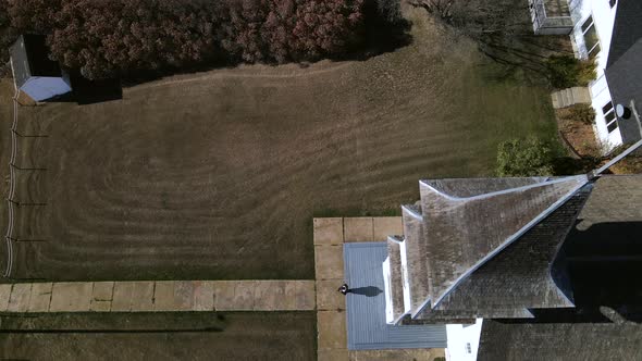 4k aerial footage of person leaving an old wooden prairie church in rural Alberta. Young man walking