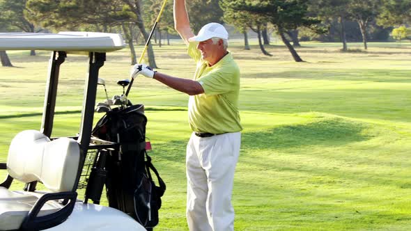 Male golfer putting golf club in golf bag