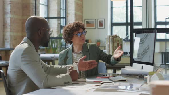 Diverse Architects Discussing Project over Coffee in Office