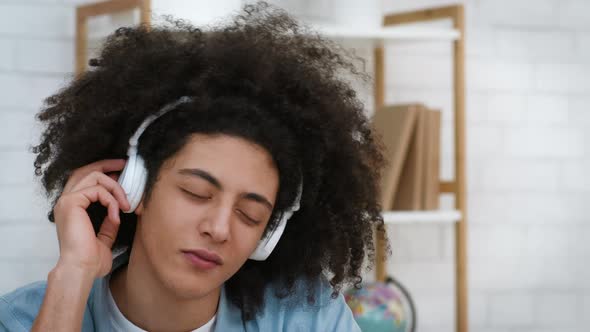 BushyHaired Millennial Guy Listening To Music Wearing Wireless Headphones Indoors