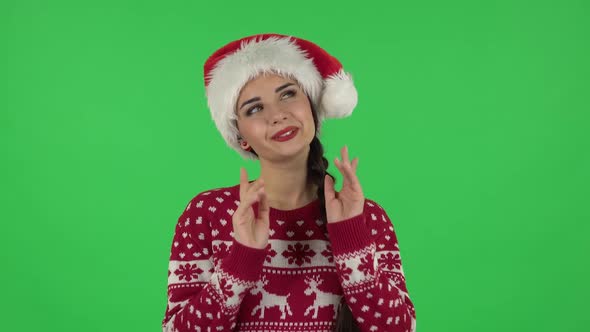 Portrait of Sweety Girl in Santa Claus Hat Is Daydreaming and Smiling Looking Up. Green Screen