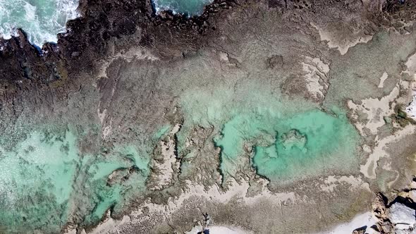 Aerial view of remote beach tidal pool man walk, Western Cape, South Africa.