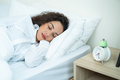 Latino beautiful woman lying down on bed in bedroom in early morning. - PhotoDune Item for Sale