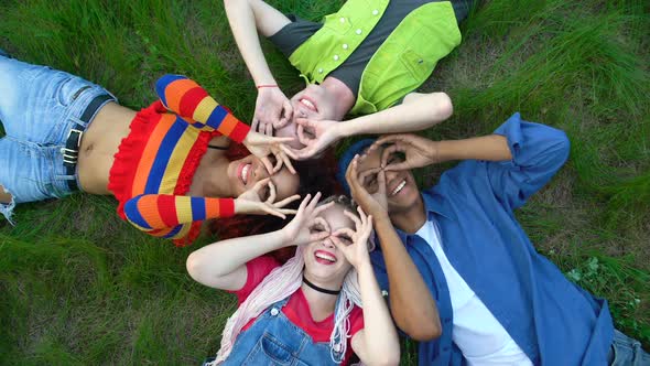 Happy Young People Showing Ok Gesture Like Binoculars Lying Campus Park Grass