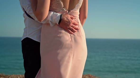 Newlyweds a Young Couple at a Romantic Meeting on the Seashore a Dress in the Wind Slow Motion