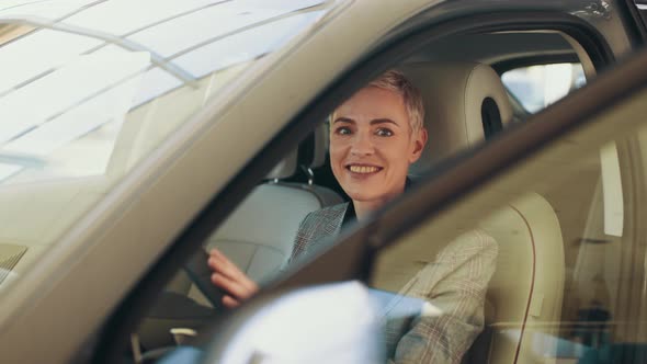 Attractive Caucasian Woman Sitting Behind the Wheel of New Modern Car and