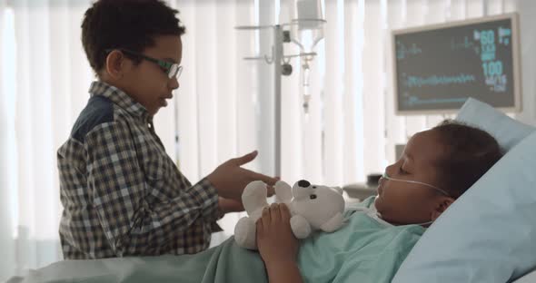 Little African Boy Visiting Sick Sister in Hospital Ward