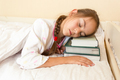 portrait of little girl using pile of books instead of pillow - PhotoDune Item for Sale